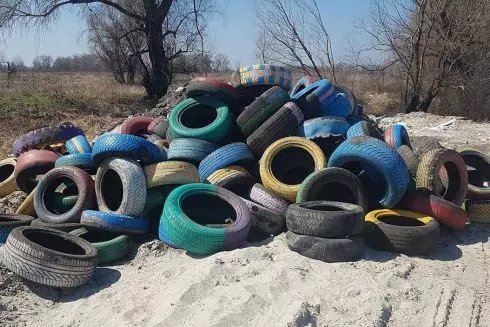 Фото: у Деснянському районі старі покришки викинули в поле замість необхідної утилізації