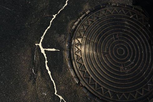 Фото дня. Киевский художник заливает асфальтовые трещины позолотой