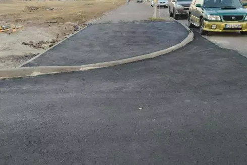 Фото. Супермаркет на Троєщині заасфальтував перехід з тактильною плиткою та газоном для свого заїзду