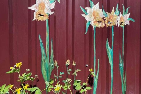 Фото дня. Как в Буче следы от пуль на заборах превращают в цветы