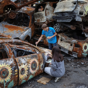 Фото: Художники разрисовывают поврежденные автомобили в Ирпене