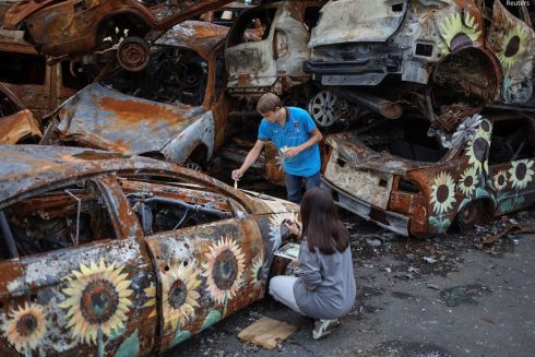 Фото: Художники разрисовывают поврежденные автомобили в Ирпене