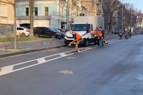 Фото. На Золотоворітській відновлюють делініатори, які захищали велосмугу від паркування автівок