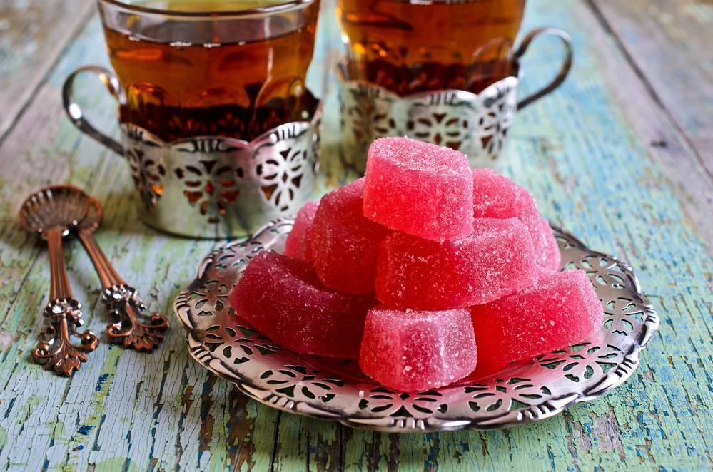 Candy pink jelly sprinkled with sugar lie on beautiful metallic saucer